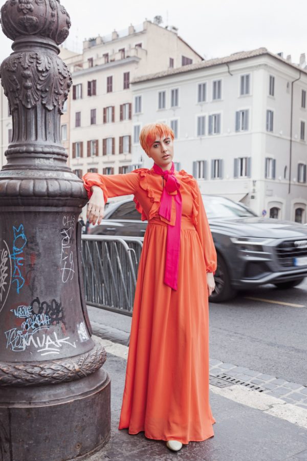 Red dress woman standing next to a thing